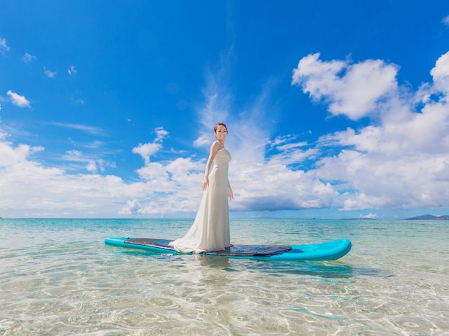 「沖縄ウェディングオンライン」の、海の上にボードを浮かべて撮影した新婦