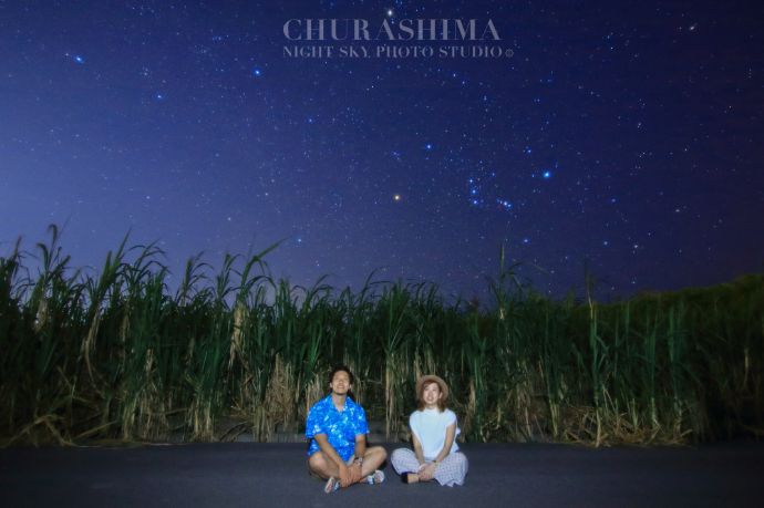 「CHURASHIMA NIGHT SKY PHOTO STUDIO」で撮影されたさとうきび畑のそばに座る二人