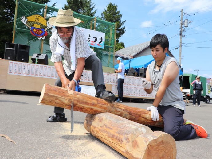 愛別町の夏祭りで木材を切る町民