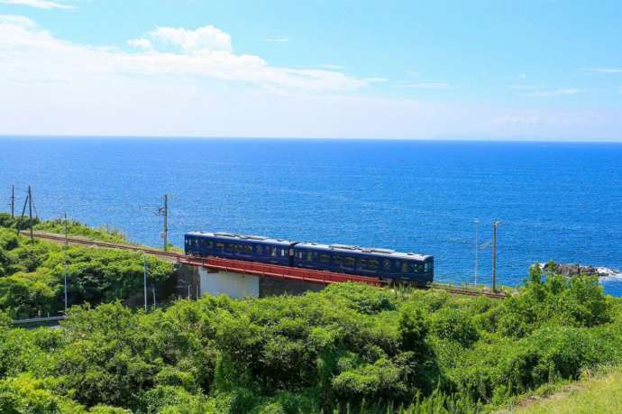 海をバッグに肥薩おれんじ鉄道を電車が走る風景