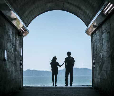 トンネルを抜けた先に広がる御立岬海水浴場を眺めるカップル