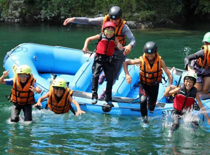 岐阜県郡上市美並町にある「長良川ラフティングのスピリット」でボートから川に飛び込む人々