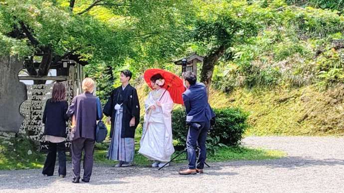 足羽神社の境内で写真撮影をする新郎新婦の様子
