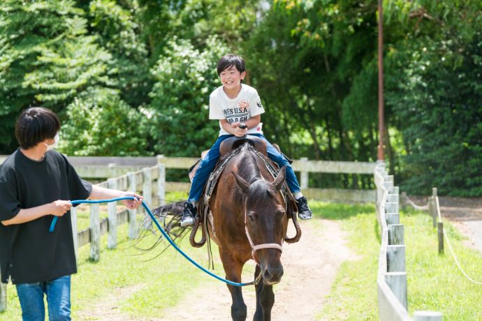 兵庫県南あわじ市にある淡路ファームパーク イングランドの丘で乗馬を楽しむ親子