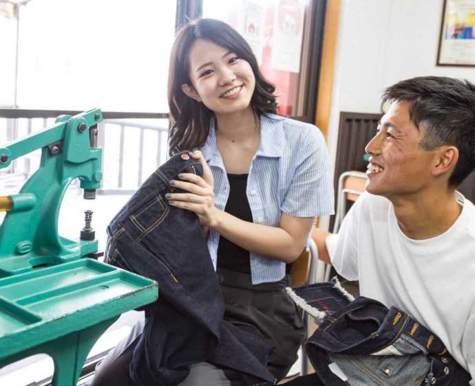 岡山県倉敷市にある「ベティスミス ジーンズミュージアム&ヴィレッジ」でジーンズ作り体験をしているカップル