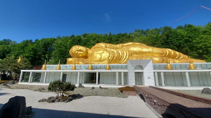 青空の下、金色が映える「舎利山 佛願寺」の涅槃大仏