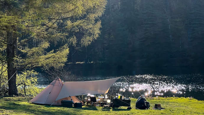 千代田湖キャンプ場の湖畔サイトにテントを張るカップル