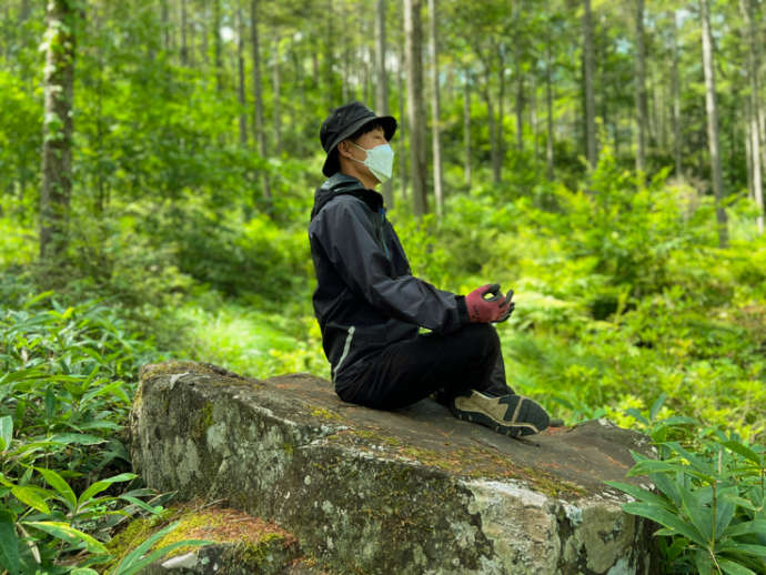 千代田湖の周辺にある「すーちん岩」の上で静かに瞑想する男性