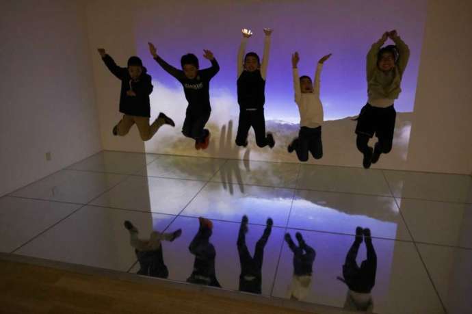 「カレイドシアター」でジャンプして写真撮影をする子どもたちの写真
