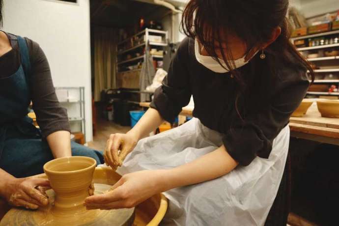 陶工房こもん堂の電動ろくろ体験に挑戦している女性