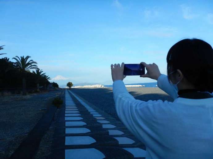 ディスカバリーパーク焼津天文科学館横の海岸で富士山を写真に収める様子