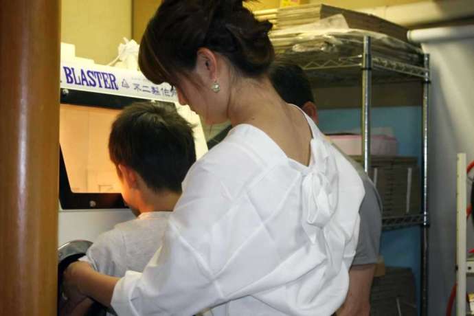 香川県観音寺市にある「創作工房どい」でのガラス彫刻体験に参加する親子