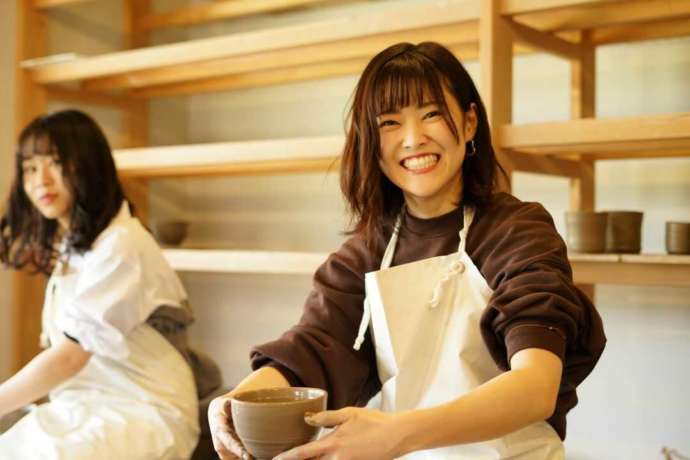 静岡県伊東市にある「陶芸工房えんのかま」で電動ろくろコースに参加する女性の笑顔