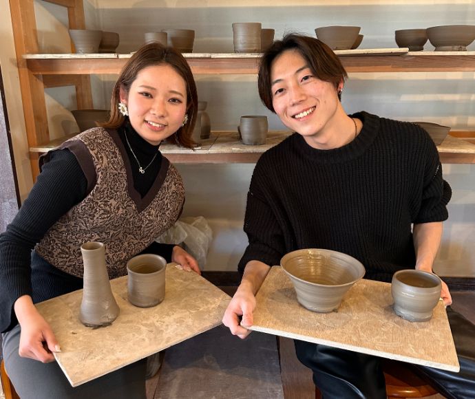 静岡県伊東市にある「陶芸工房えんのかま」で制作した作品と一緒に記念撮影をするカップル