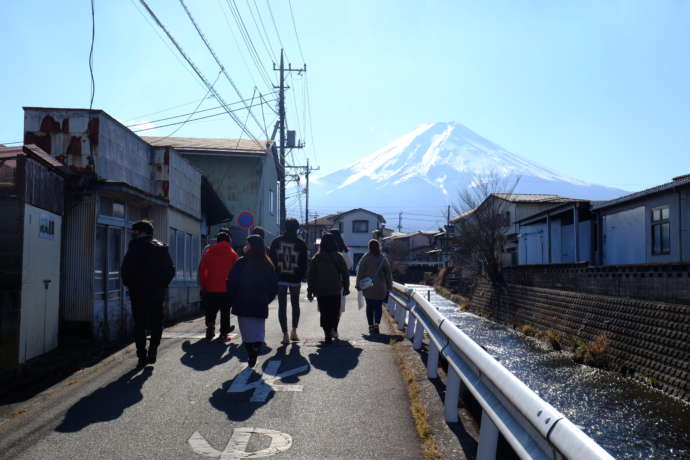 正面に富士山を見ながら道路を歩く人々
