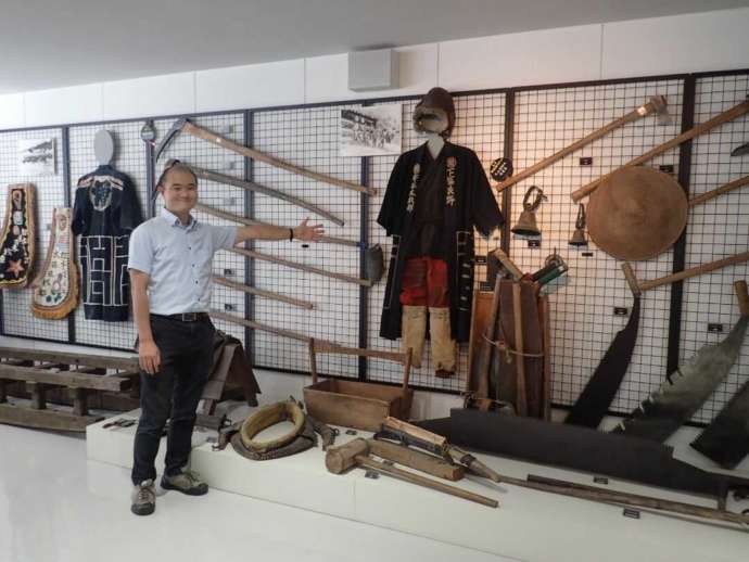 「富良野市博物館」に展示中の昔の林業道具と学芸員の泉さん