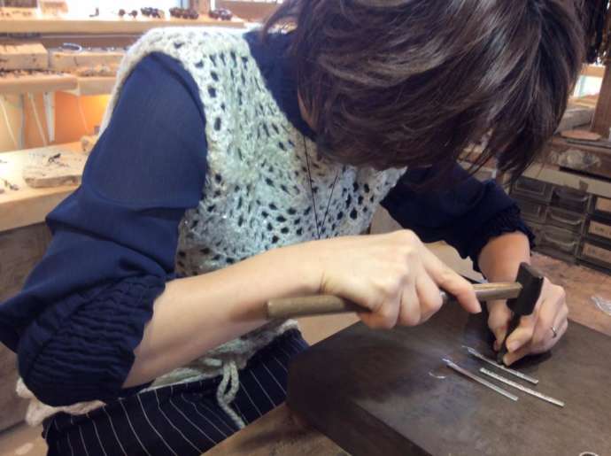 沖縄県うるま市にある「雑貨屋HAMAKICHI」でアクセサリーを作っている女性
