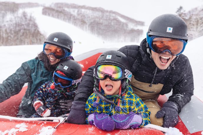 ニセコHANAZONOスキー場でスノーラフティングを楽しむ家族連れ