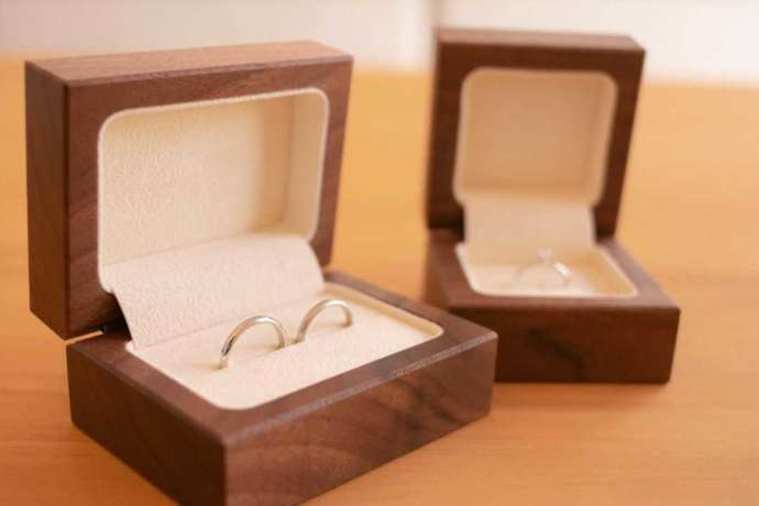 木目調のリングケースに入った結婚指輪と婚約指輪