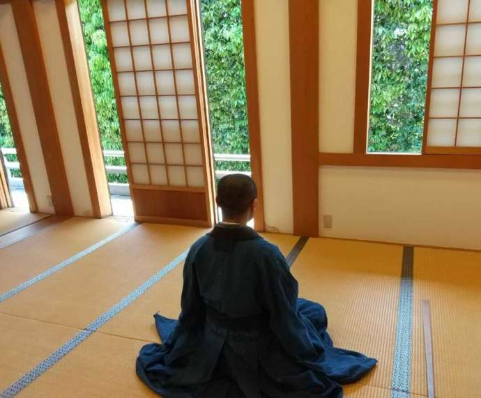 東京都小平市にある「臨済宗円覚寺派 平安院」で坐禅をする住職を背面から眺める
