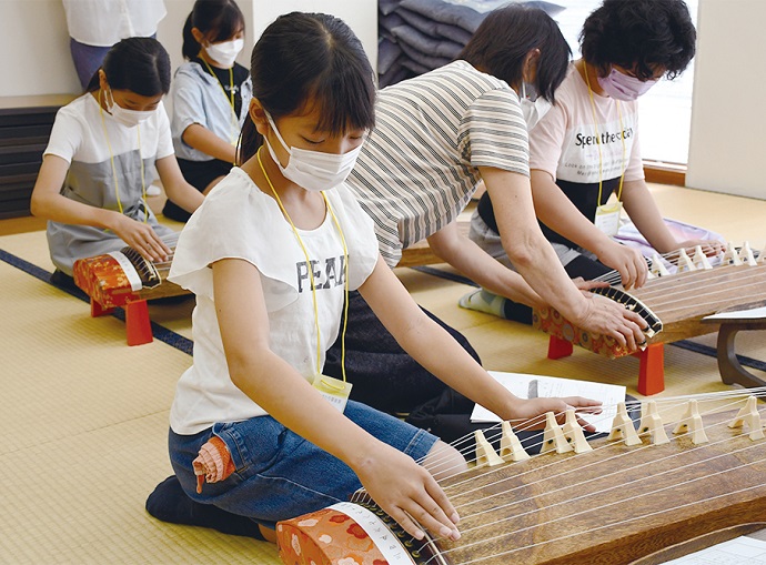 「ひ・まわり探検隊」の活動で、琴を弾く子ども達