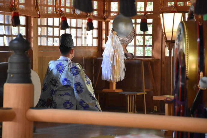 伊奈冨神社の拝殿内で儀式を行う神職