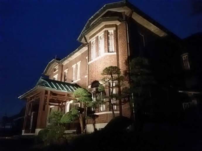 「旧石川組製糸西洋館」の正面外観（本館・夜間ライトアップ時）