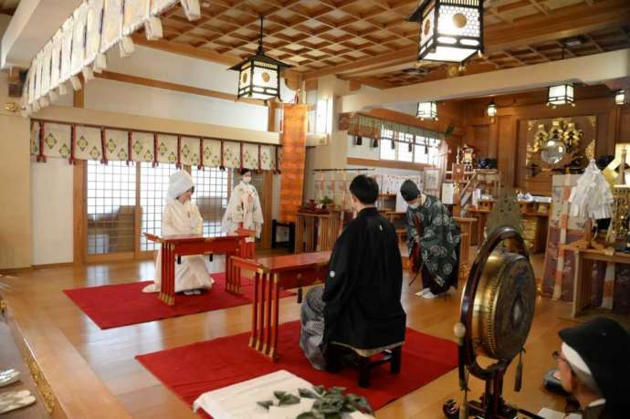 彌彦神社の神前式で神職と巫女が儀式を行う様子