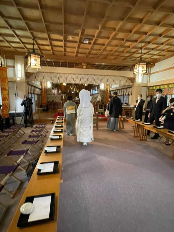 彌彦神社の神前式で新郎新婦の入場を親族が迎える様子