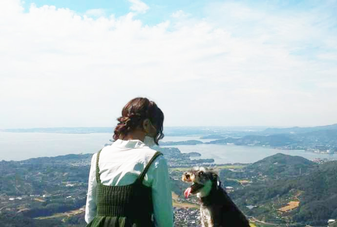 絶景パラグライダー場見学ツアーで訪れる山頂で愛犬と一緒に寛ぐ様子
