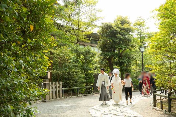 鎌倉古今にある緑豊かな庭で家族と交流する新郎新婦