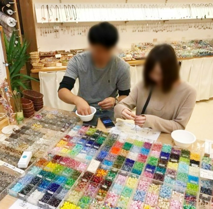 軽井沢ガラスギャラリーアームスで、トンボ玉体験後のアクセサリー作りをしているカップル