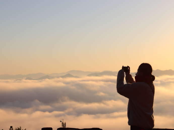 丸山城跡から見える雲海を撮影する女性