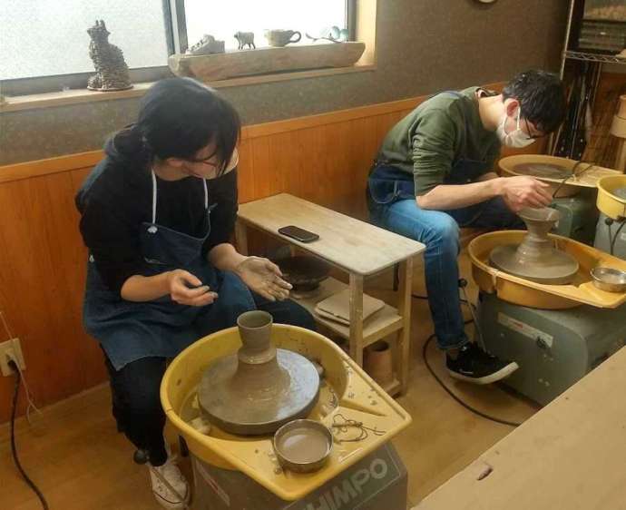 新潟県柏崎市にある「陶芸教室＆ギャラリー アトリエ九禅」で陶芸に集中しているカップル