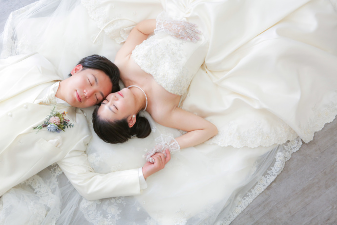 東京都八王子市のルコンテで寝転がってポーズをとる新郎新婦