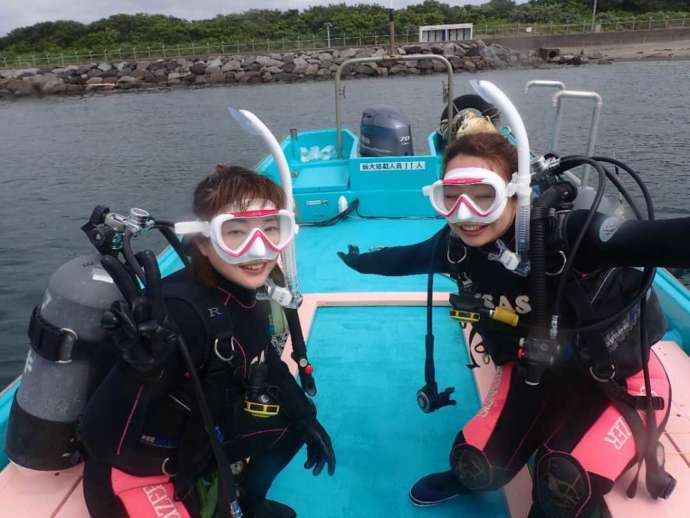 「沖ノ島ダイビングサービス マリンスノー」のボート上でポーズをとる女性たち