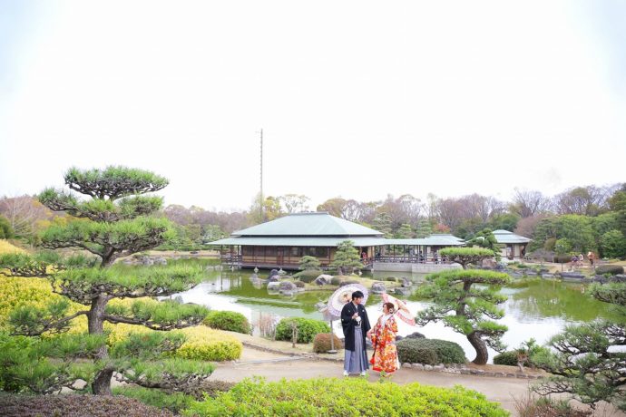 大仙公園日本庭園で番傘をさす和装の衣装に身を包む新郎新婦