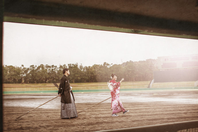 万博記念公園野球場でトンボをかける和装の衣装を着た新郎新婦