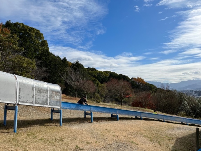 愛媛県松山市にある公園の長い滑り台で遊ぶ親子の写真