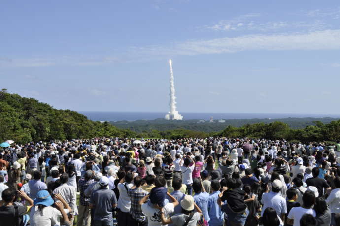 長谷展望公園に集まる人々とそこから見えるロケット発射の写真