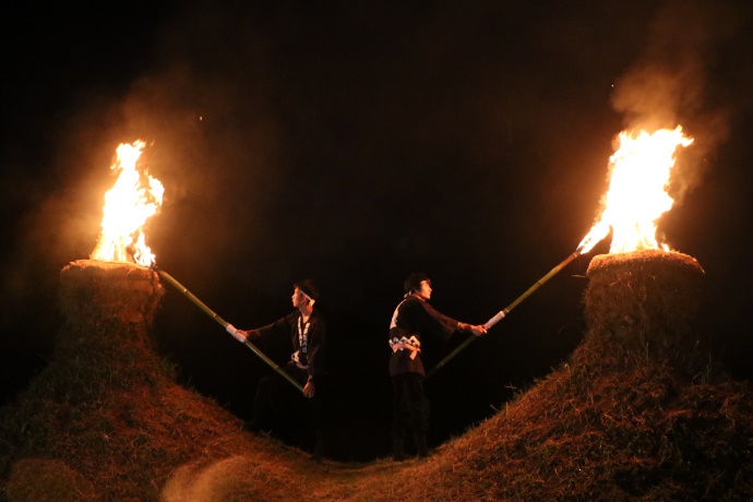 「猪俣の百八燈」で塚に火をともす人々