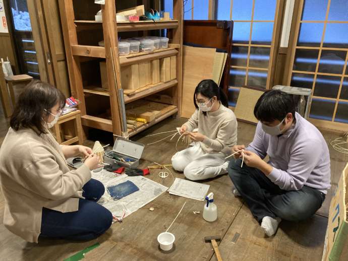 福島県三島町の移住体験ツアーで編み込み細工を楽しむ参加者