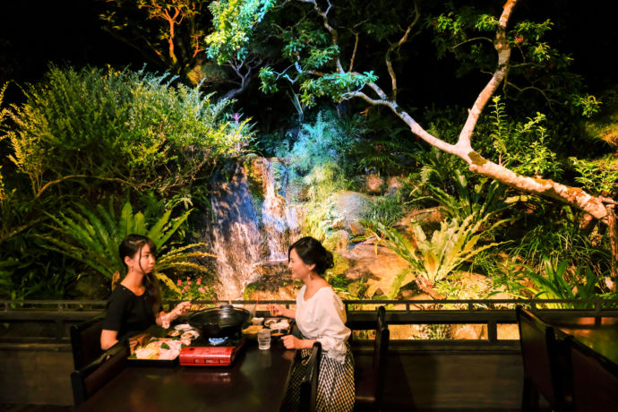「百年古家 大家」の周囲に広がる自然を眺めながら食事を楽しむ女性たち