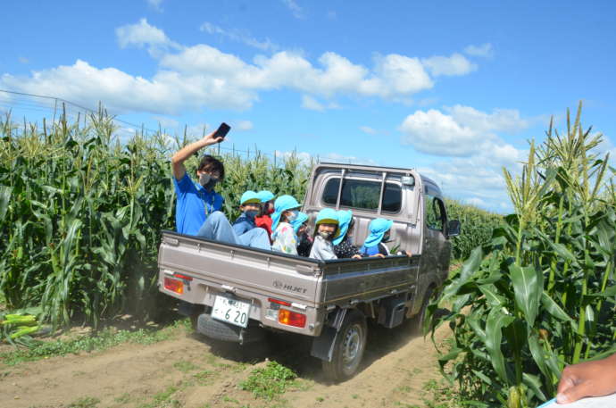 南幌町の農家さんの軽トラで野菜の収穫に向かう子どもたち