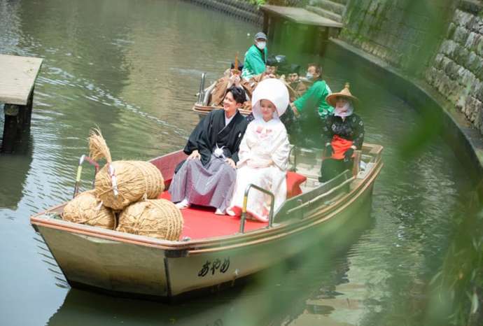 花嫁船に乗って小野川を下る新郎新婦の写真