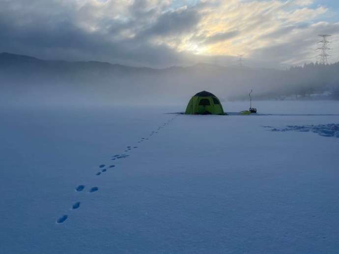 雪がつもった湖の上に、わかさぎ釣りのテント