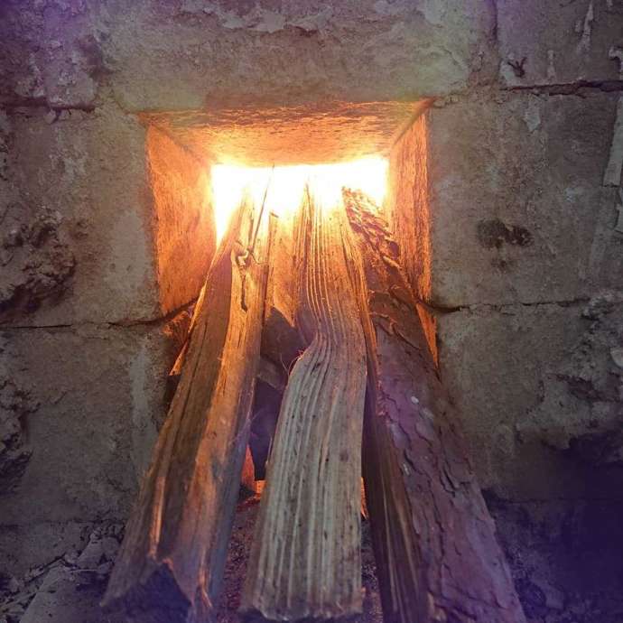 「出張陶芸HOSHI」にある昔ながらの大窯（登り窯）に赤松の薪（まき）をくべる様子