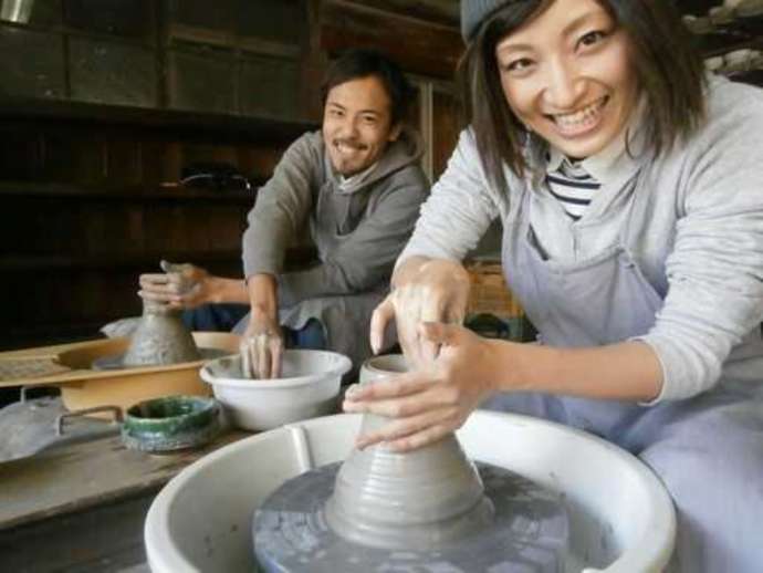 「角山製陶所」の「陶芸体験（電動ロクロ体験）コース」で作陶中のカップル（その1）