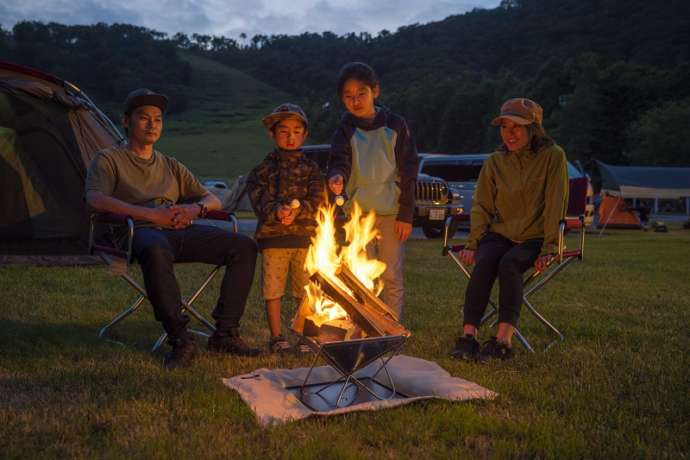 ルスツ山はともだちキャンプ場でたき火をする家族