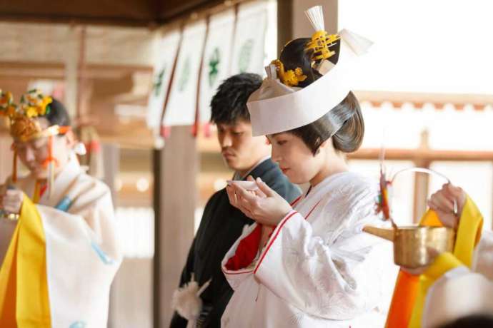 佐嘉神社の神前式で三三九度の儀式をしている新郎新婦